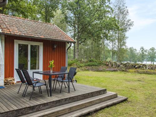 a wooden deck with a table and chairs on it at Chalet Ängsjömåla - B in Eringsboda