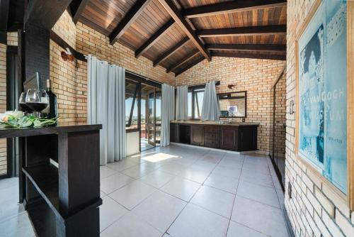 a room with a brick wall and wooden ceilings at Pousada Albacora in Bombinhas