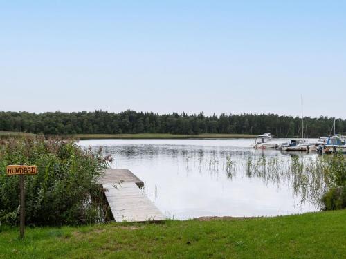 a small dock on a lake with boats in the water at Chalet Västanvik Snickarhagen by Interhome in Motala