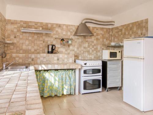 La cuisine est équipée d'une cuisinière blanche et d'un réfrigérateur. dans l'établissement Holiday Home Salamnbo by Interhome, à Châteaudouble