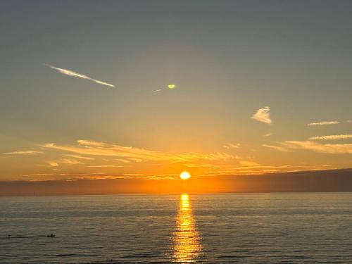 una puesta de sol sobre el océano con la puesta de sol en Holiday Home Rusthoeve by Interhome, en Sint Maartensvlotbrug