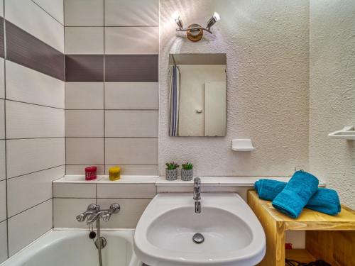 une salle de bain avec un lavabo, une baignoire et un miroir dans l'établissement Apartment Vostok Zodiaque-50 by Interhome, au Corbier