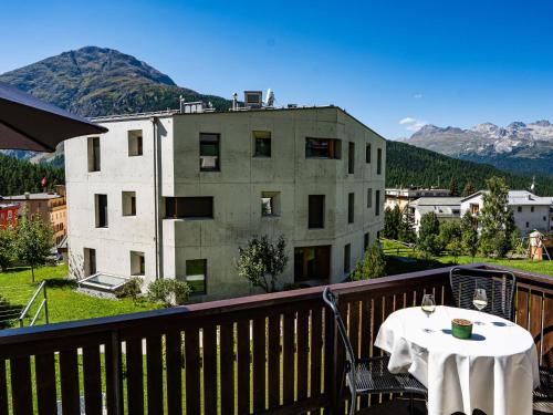 a table on a balcony with a view of a building at Apartment Chesa Corvatsch by Interhome in Pontresina
