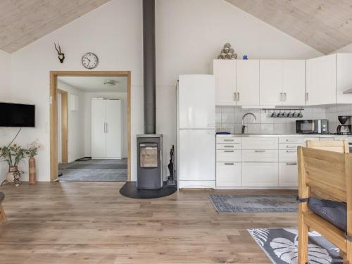 eine Küche mit weißen Schränken und einem Herd in der Unterkunft Holiday Home Gaslunda by Interhome in Olofström