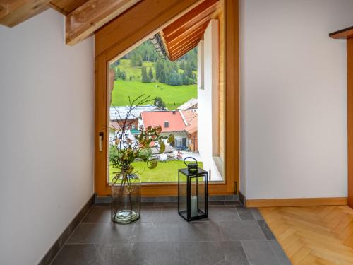 Zimmer mit einem großen Fenster und einem Tisch mit einer Vase in der Unterkunft Apartment Kathrein - ISL507 by Interhome in Ischgl