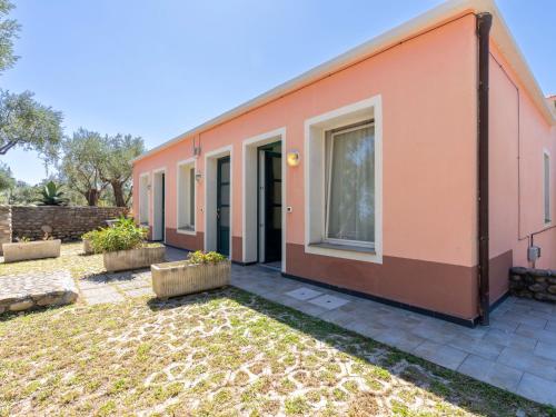 ein orangenes Haus mit einem Garten davor in der Unterkunft Apartment Borgoverde-3 by Interhome in Imperia