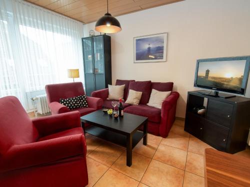 ノルトダイヒにあるApartment Leuchtfeuer by Interhomeのリビングルーム(赤い家具、薄型テレビ付)