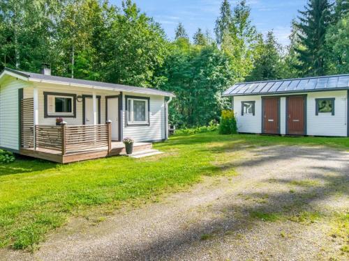 a tiny house with a porch and a garage at Holiday Home Eteläaho by Interhome in Nykälä