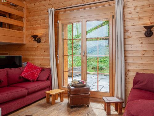 un soggiorno con divano rosso e finestra di Chalet Mimique by Interhome a Nendaz