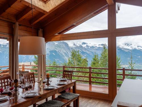 - une salle à manger avec une table et une vue sur les montagnes dans l'établissement Chalet Mimique by Interhome, à Nendaz