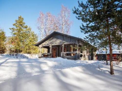 uma casa na neve com uma árvore em frente em Holiday Home Marttalanmäki by Interhome em Valittula