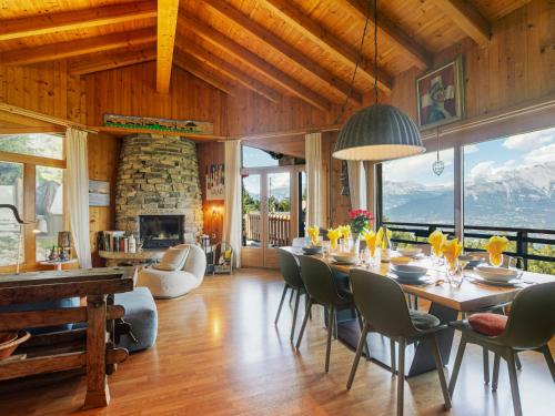 a dining room with a table and chairs and a fireplace at Chalet Mayens by Interhome in Agettes