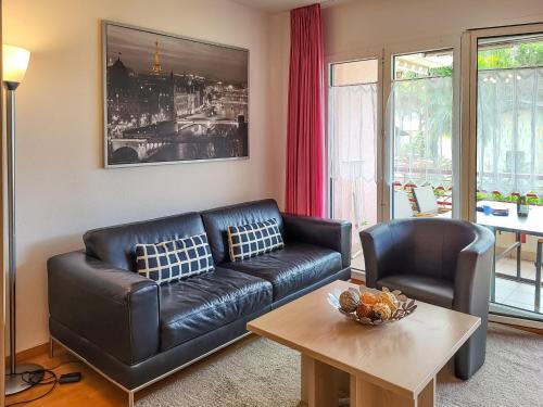 a living room with a leather couch and a table at Apartment Caslago-1 by Interhome in Caslano