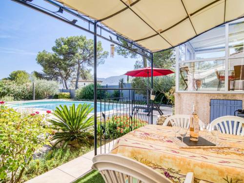 un patio avec une table et des chaises et une piscine dans l'établissement Holiday Home Les Hauts de Palayson by Interhome, au Muy