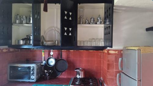 a kitchen with a microwave and a stove top oven at Soultana 2 pour les familles in Oualidia