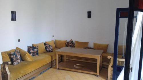 a living room with a couch and a table at Duplex 2 pour les familles in Oualidia