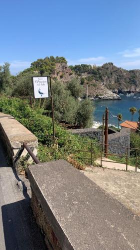 a sign on the side of a road next to a body of water at Isola Bella - Rooms il Pescatore in Taormina