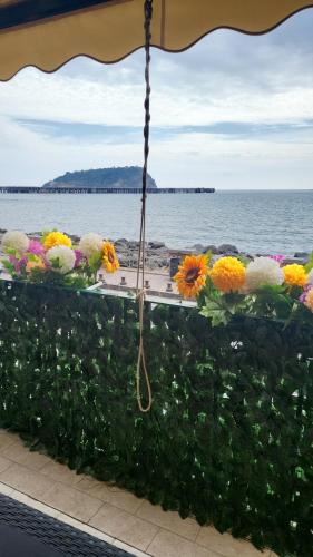einen Blick auf das Meer aus einem Fenster mit Blumen in der Unterkunft Hotel taromy in Neapel