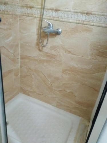 d'une douche avec une porte en verre et un pommeau de douche. dans l'établissement Bel Appartement, à Oujda