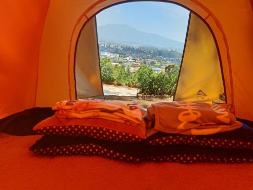 a bed in a room with a window at Glamping ReaVeeCafe Puncak in Puncak