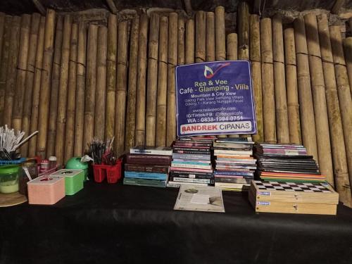 stos książek siedzących na stole w obiekcie Glamping ReaVeeCafe Puncak w mieście Puncak