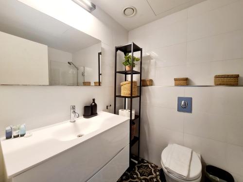 Gindi Tower Apartment - By Beach Apartments TLV في تل أبيب: حمام مع حوض ومرحاض