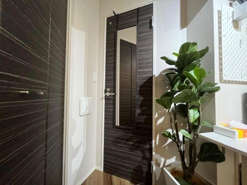 a bathroom with a black door and a plant at Meguro-ku - House - Vacation STAY 8878 in Tokyo