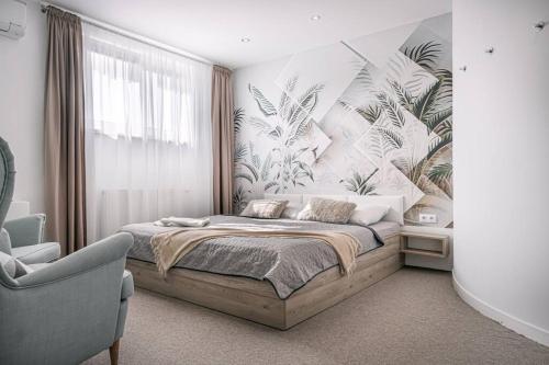 a bedroom with a large bed and a chair at Apartments by Pyramid: Christoph in Bratislava