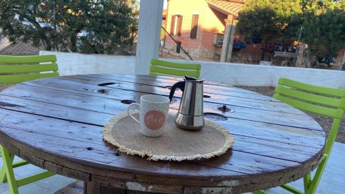 uma mesa de madeira com uma caneca de café em cima em Domu Istella em SantʼAnna Arresi