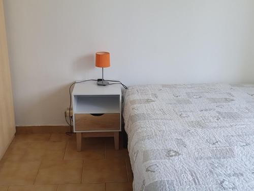 une chambre avec un lit et une lampe sur une table de chevet dans l'établissement Appartement RDC avec jardin proche du port, terrasse, parking privé, idéal couple/enfant, animaux OK - FR-1-418-171, au Palais