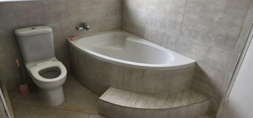 a bathroom with a bath tub and a toilet at Lovely 3 bed in Mount Pleasant - 2153 in Kingsmead