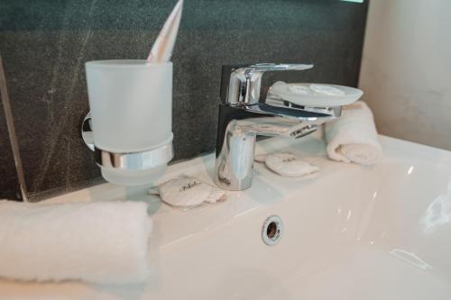a bathroom sink with a faucet and a roll of toilet paper at Hotel Boutique Refael in Truskavets