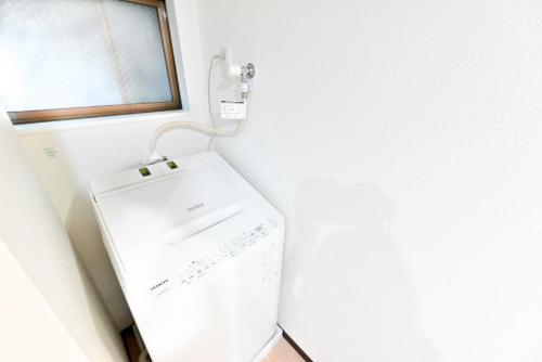 a white refrigerator in a room with a window at Ueno 3m to Train 161m2 Villa 6BR 3Bath 4Toilet Skytree View in Tokyo