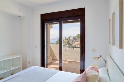 um quarto com uma cama e uma porta de vidro deslizante em iloftmalaga Pinares de San Antón em Málaga