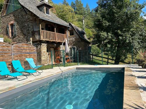 a swimming pool in front of a house at Maison d'Hélène in Cassaniouze