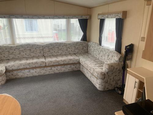 a living room with a couch in front of a window at K&Ds Caravans in Chapel Saint Leonards