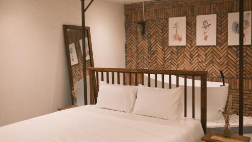 uma cama com cabeceira em madeira e almofadas brancas em Vũ House Phú Yên- Boutique Room & Breakfast em Tuy Hoa