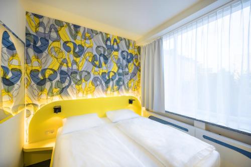 a hotel room with a bed and a window at Prize by Radisson, Dortmund City in Dortmund