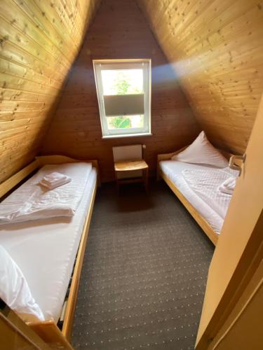2 camas en una habitación pequeña con ventana en Hostel, Gästehaus zum Molenfeuer, en Warnemünde