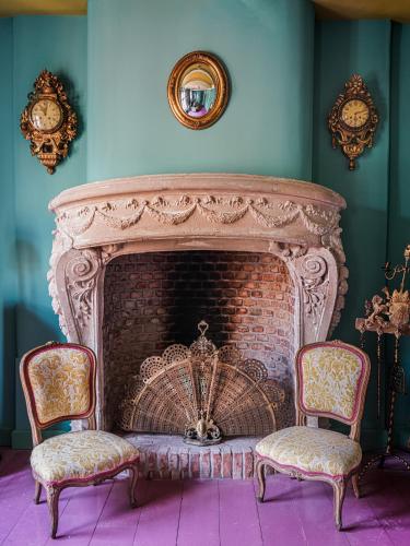 a living room with a fireplace with two chairs at Private and chique Salon de Franz in Amsterdam