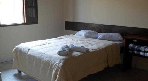 1 dormitorio con 1 cama con 2 toallas en POUSADA PEQUIZEIRO, en Chapada dos Guimarães