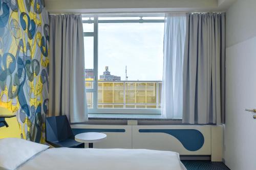 a hotel room with a bed and a window at prizeotel Dortmund-City in Dortmund