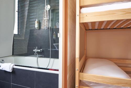 La petite salle de bains est pourvue de lits superposés et d'une baignoire. dans l'établissement Greet Boulogne Billancourt Paris, à Boulogne-Billancourt