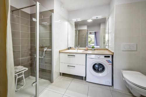 a bathroom with a washing machine and a shower at OVELIA Toulouse - Les Bastides de Lardenne in Toulouse