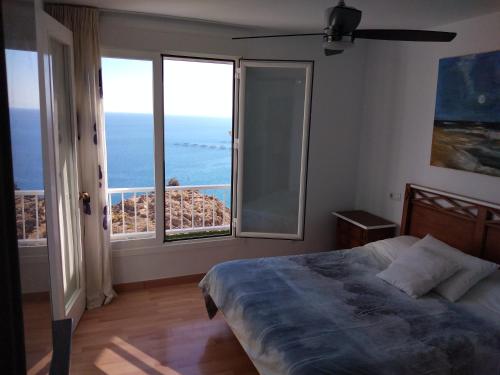 a bedroom with a bed and a view of the ocean at De la Montaña al Mar in Almería