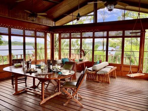 a living room with a table and chairs on a deck at Akwaba Lodge in The Gap