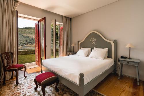 een slaapkamer met een bed en een groot raam bij Quinta Dona Matilde in Peso da Régua