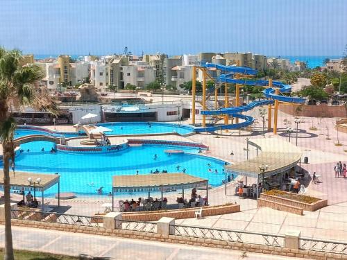 a large swimming pool with a water park at فلا ١٨٦ in Alexandria