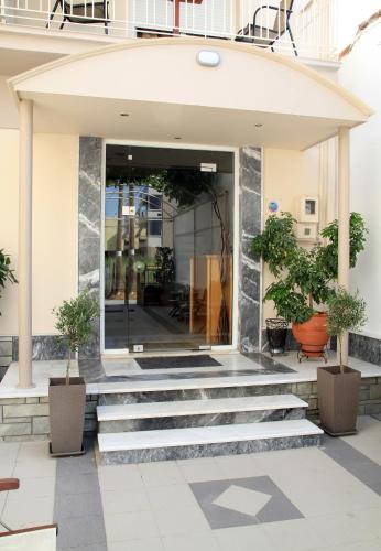 a lobby of a building with stairs and potted plants at Hotel Stella in Volos
