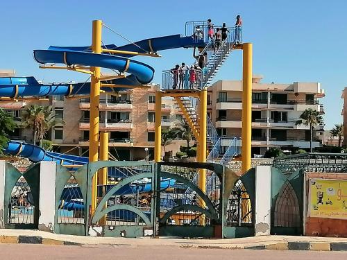 a roller coaster at a theme park with people on a roller slide at فلا ١٨٦ in Alexandria